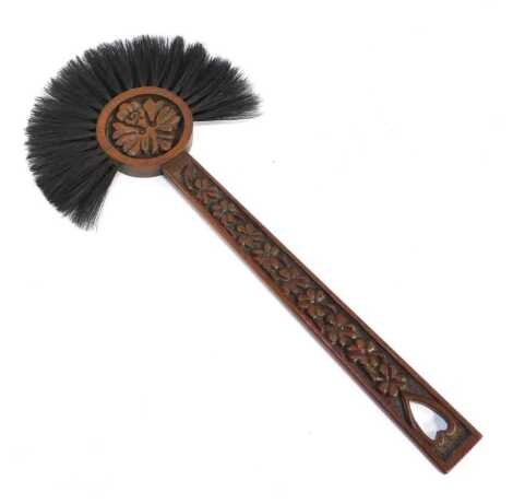 A carved oak Welsh hearth brush, decorated with leaf motifs and pierced heart to handle, 71cm long.