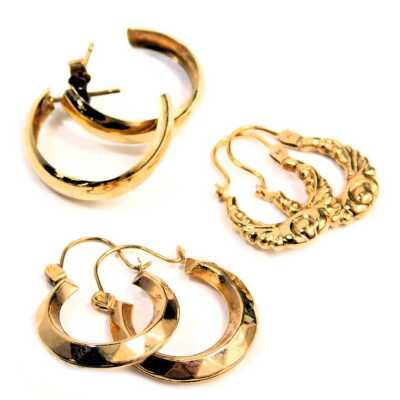 Three pairs of hoop earrings, comprising a pair of hammered hoop yellow metal earrings, a pair of floral scroll yellow metal hoops, unmarked, and a pair of gold plated hoops, 1.8g all in. (3)