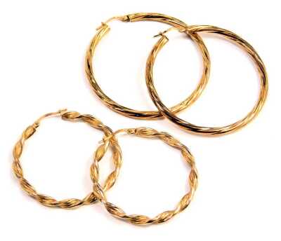 Two pairs of 9ct gold hoop earrings, comprising a pair of twist design, 4cm wide, and a light twist pair, 5cm wide, 7.5g all in. (2)