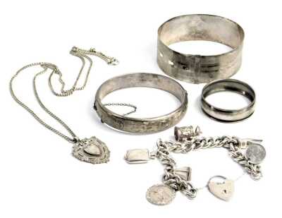 Various silver and other jewellery, comprising a silver curb link charm bracelet, with safety chain heart shaped padlock, tankard charm, etc., two bangles, one hallmarked silver, the other stamped sterling silver, a silver chain and shield fob, and a thin