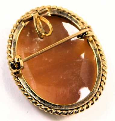 A 9ct gold framed shell cameo brooch, depicting a maiden-looking dexter, in a rub-over border with twist setting, on a single pin back, 2.5cm x 3cm, 5.6g all in. - 2