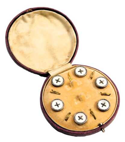 A cased set of 1940s/1950s gentleman's collar studs, each with a white metal border, and a mother of pearl central button with cross design, in a fitted case.