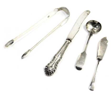 A pair of Georgian silver sugar tongs, with bright cut engraving, a Victorian silver handled and steel bladed butter knife, a Victorian silver mustard spoon, maker CW, and a George V silver butter knife, 2.64oz gross. (4)