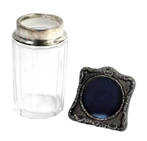 Two silver items, comprising a miniature silver framed photograph frame, 6cm high, and a silver rimmed and cut glass dressing table jar, 11cm high. (2)