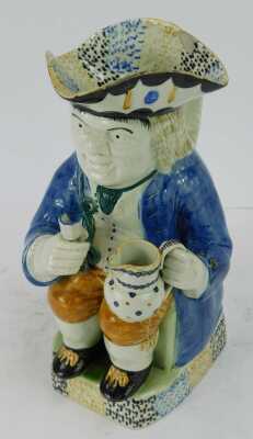 An early 19thC pearlware Toby jug, modelled as a seated gentleman in a tricorn hat holding a jug in one hand and goblet in the other, 27cm high. - 2