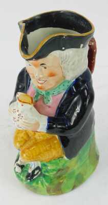 A 19thC pottery Toby jug, modelled as a seated gentleman in tricorn hat grasping a jug in two hands, 23.5cm high. - 2