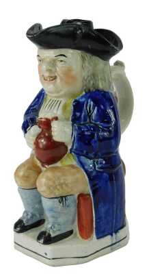 A 19thC pottery Toby jug, modelled as a seated gentleman wearing a tricorn hat, with a lid, holding a tankard containing beer and pipe, 24cm high.