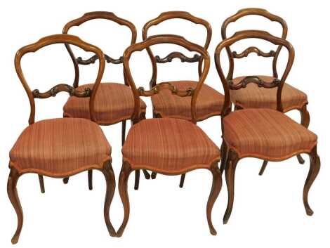 A set of six Victorian rosewood balloon back dining chairs, each with a scroll carved rail, overstuffed seat, on cabriole legs.