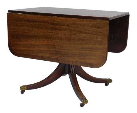 A 20thC mahogany and line inlaid drop leaf table, in 19thC style, the top with a rounded edge, on a turned column with outsplayed legs, with brass lined paw capped castors, 74cm high, 91cm wide, 60cm deep, 142cm extended.