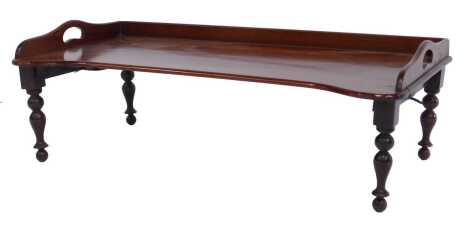 A Victorian mahogany two handled bed tray, by Carter's of London, No 25296, bearing label, the shaped top with a raised back, on turned tapering stained beech legs, 22cm high, 68cm wide, 36cm deep.