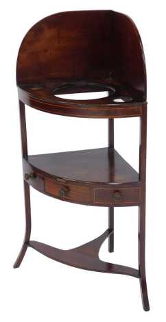 A George III mahogany and boxwood line inlaid corner wash stand, the top with a raised back with three recess above a recess with three drawers and an under tier, on outswept legs, 110cm high, 57cm wide, 36cm deep.