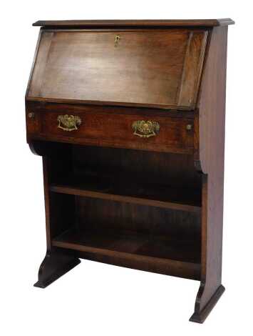 An early 20thC oak student's bureau, the fall enclosing an arrangement of recesses above a frieze drawer with two open shelves to base, on moulded feet, 107cm high, 76cm wide, 30cm deep.