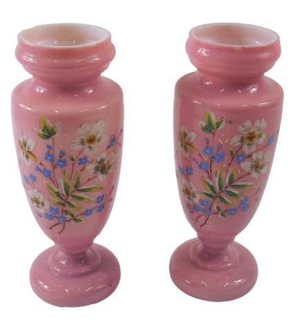 A pair of Victorian pink opaque glass vases, each decorated in coloured enamel, with flower and leaf sprays, 27cm high.