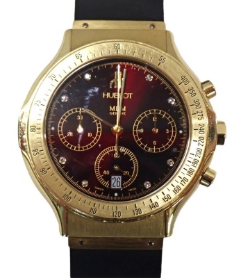 A Hublot Elegant MDM Power Reserve Burma chronograph wristwatch, with a wine red dial, in yellow metal case marked 750, on a black material elasticised strap, marked 16213 440757, boxed, the dial 3.5cm diameter, 86.1g all in. (AF)