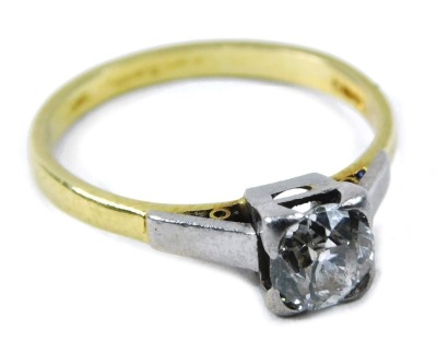 An 18ct gold diamond solitaire ring, the round brilliant cut diamond in four claw tension setting, the stone approximately 0.23-25ct, on white gold shoulders, on yellow metal band, ring size N, 2.9g all in.