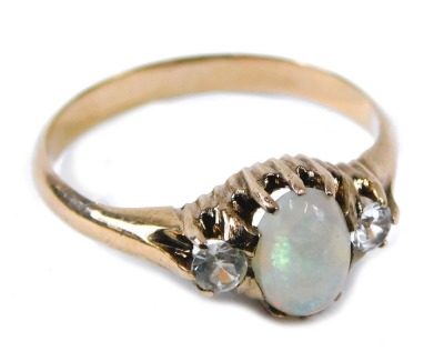 A three stone dress ring, the central set with oval opal, in claw setting, flanked by two illusion set diamonds, on rose gold band, unmarked, ring size M½, 2.4g all in.