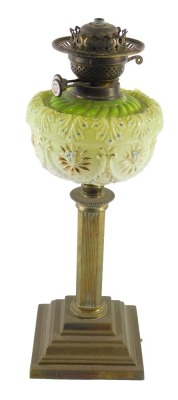 A Victorian brass oil lamp, with green opaque glass reservoir, over painted with flowers picked out in gilt with spots, 50cm high.