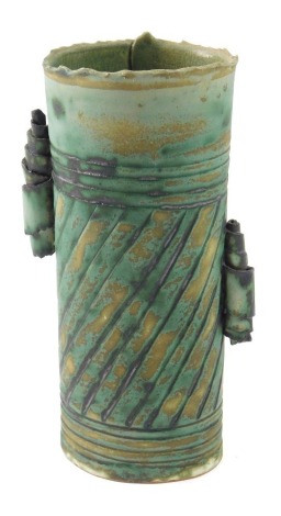 A Lyn Lovitt Studio Pottery vase, decorated in shades of green and brown, with scroll side handles, seal mark to side, 15cm high.