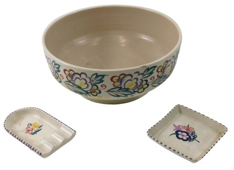 A Poole Pottery bowl, decorated with a band of flowers and leaves, 28cm diameter, (AF), a Poole ash tray, and a pin dish. (3)