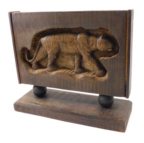 A rectangular panel carved with a tiger, on spherical supports, with rectangular plinth, 39cm wide.