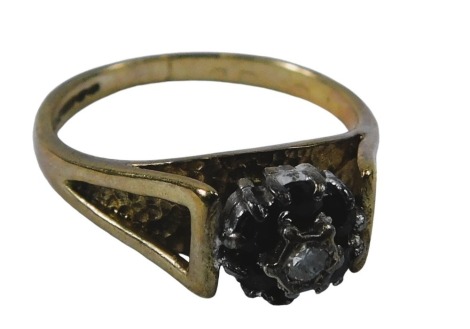 A 9ct gold cluster ring, the central cluster set with six sapphires, and centred by a diamond, on V splayed raised shank, on a bark effect hammered ring head, maker WEG, Birmingham 1978, ring size M, 3g.