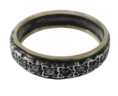 An eternity ring, the central silvered design set with marcasite, bordered by gold border, stamped 9ct gold sil, some stones missing, ring size K½, 2.3g all in.