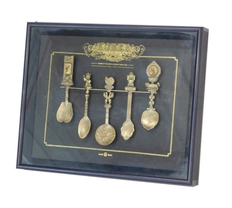 A set of five Korean Olympics commemorative spoons, in glazed case, 32cm wide.