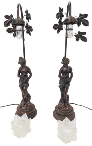 A pair of bronzed metal and resin figural table lamps, each with frosted shades, 66.5cm high. (AF) WARNING! This lot contains untested or unsafe electrical items. It is supplied for scrap or re-conditioning only. TRADE ONLY