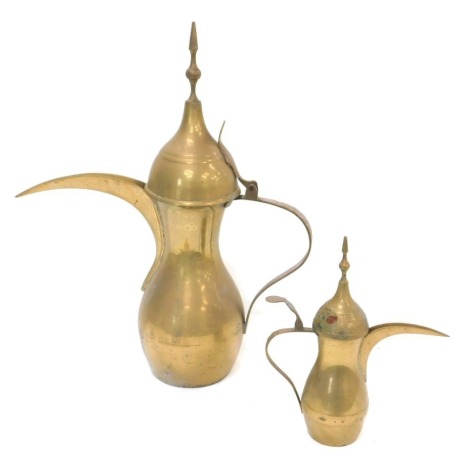 A Middle Eastern brass coffee pot, with hinged lid, 62cm high, and a smaller version.