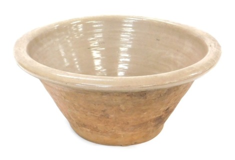 A buff coloured dairy bowl, with glazed interior and rim, 44cm diameter.