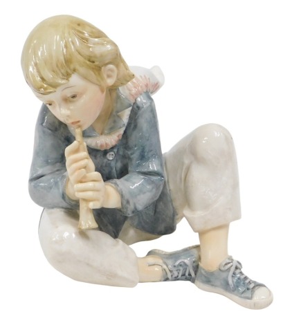 A Santini resin figure of seated child playing flute, bearing signature, 26cm high.