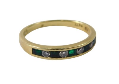 An 18ct gold emerald and diamond half hoop dress ring, set with five square cut emeralds and four round brilliant cut diamonds, each tension set, ring size L, 2.3g all in.