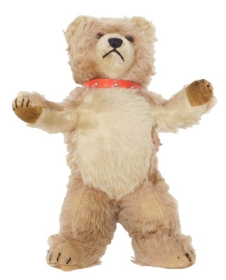 A 19thC cream and beige ring haired teddy bear, with felt pads and later red plastic and copper collar, 38cm high.