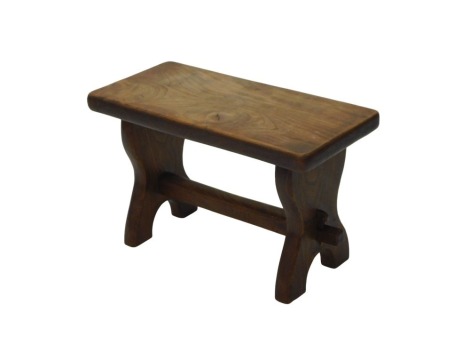 A rustic elm stool or occasional table, with shaped end supports, and plain stretcher, 60cm wide.