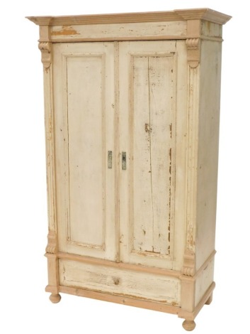 A cream painted pine two door wardrobe, with drawer to base, on bun feet, 186cm high, 112cm wide.