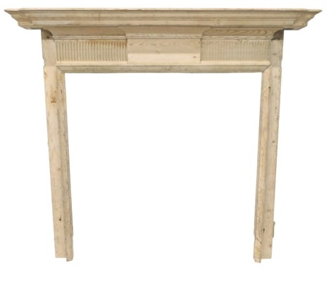 A stripped pine fire surround, with a breakfront moulded mantel, above a part fluted frieze with central tablet, 133cm high, 149cm wide. (AF)