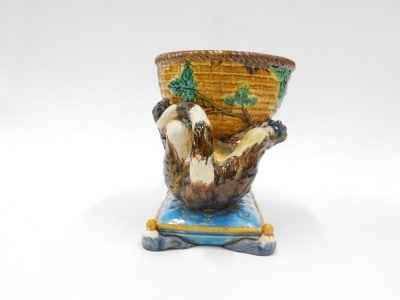 A Majolica centrepiece or jardiniere, modelled in the form of cat holding a basket, seated on a turquoise coloured cushion with gold piping, bearing Minton name to underside, 27cm high, 35cm wide. - 2