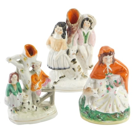 Three 19thC Staffordshire figure groups, comprising two spill vases, 17cm and 14cm high, and a figure of a woman, 14cm high. (3)