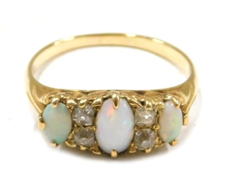 An 18ct gold opal and diamond dress ring, set with three oval opals and four old cut diamonds, ring size P, 3.9g all in.