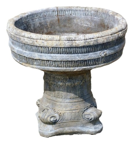 A reconstituted stone garden planter, the barrel top on a trifold base, 57cm high, 65cm wide. (AF)