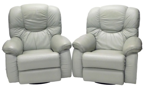 A pair of La-Z-boy green leather reclining and revolving armchairs.