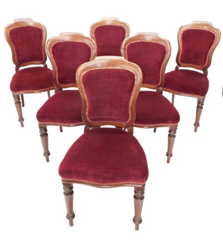 A set of six Victorian walnut balloon back chairs, each with a padded back, seat in deep red velvet, on turned tapering legs. (AF)