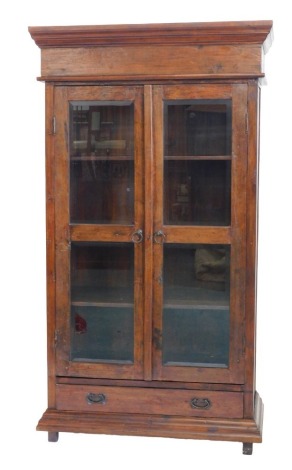 An Old Java hardwood china cabinet, the top with a moulded cornice above two glazed doors and two drawers, on stiles, 101cm high, 113cm wide.