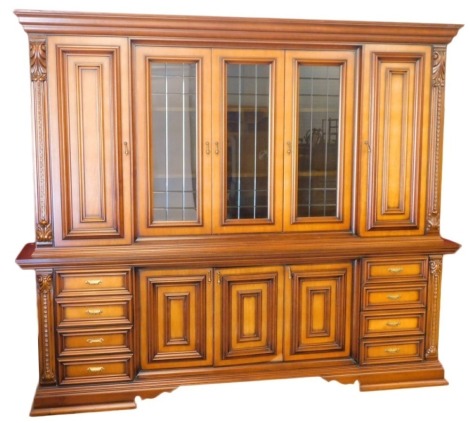 A large Continental walnut cabinet, the top with a moulded cornice above three glazed doors flanked by panelled doors and leaf capped pilasters, the base with three panelled doors and two banks of four drawers, on bracket feet, 229cm high, 170cm wide, 53c