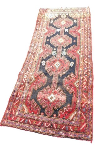 A Turkish style short runner, with a design of multicoloured medallions on a black ground, one wide and two narrow borders, 108cm x 260cm.