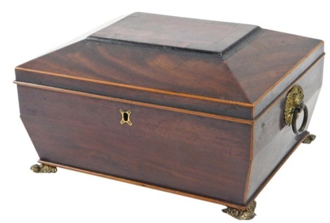 An early Victorian mahogany sarcophagus shaped workbox, interior with various compartments, pressed brass feet.