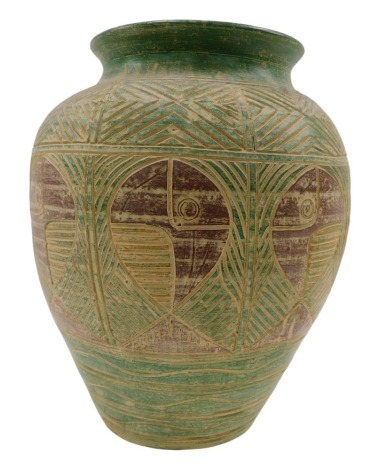 A Continental studio pottery type vase, with incised geometric design of fish, in green and maroon, 44cm high.