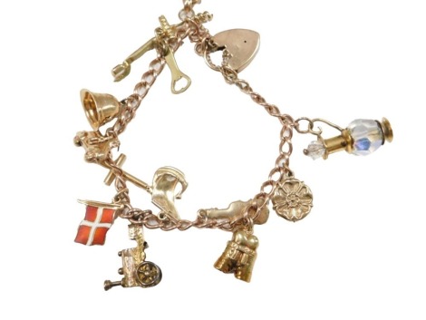 A 9ct gold charm bracelet, on thin flat curb chain, with arrangement of 9ct gold and other charms to include swivel agate fob, violin, trousers, policeman's helmet, moped, etc., 31.5g all in.