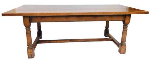 An oak refectory table, the rectangular top raised on turned legs united by a H shaped stretcher, 74cm high, the top 93cm x 213cm.