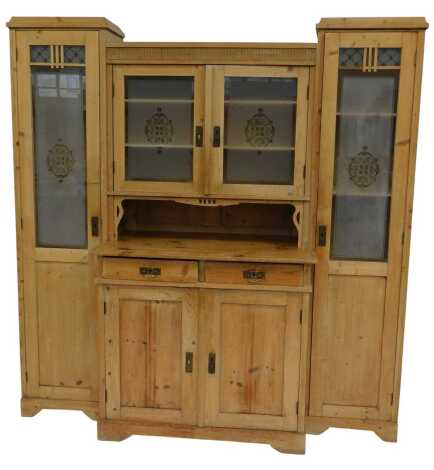 A Victorian pine breakfront cabinet, the central section with frosted glass doors enclosing three shelves with recess, the base with two drawers above two cupboards, flanked by two long cupboards with part frosted glass doors enclosing an arrangement of s